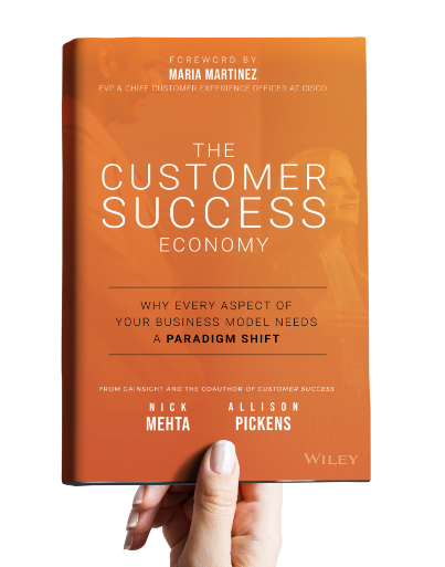 A hand holding the Customer Success Economy book